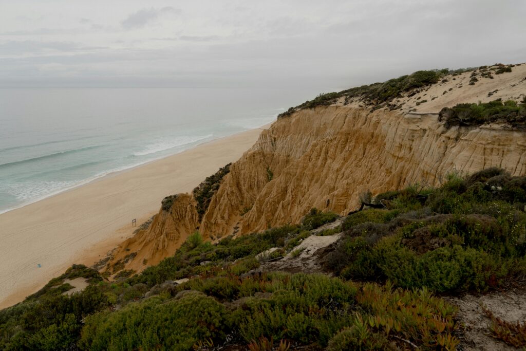 A sweeping vista of dunes spilling into white sand and Atlantic waves—emphasizes Comporta’s vast, untouched coastline
